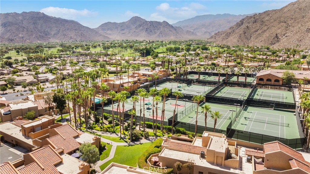 Palm Desert homes and tennis courts beneath surrounding mountains.