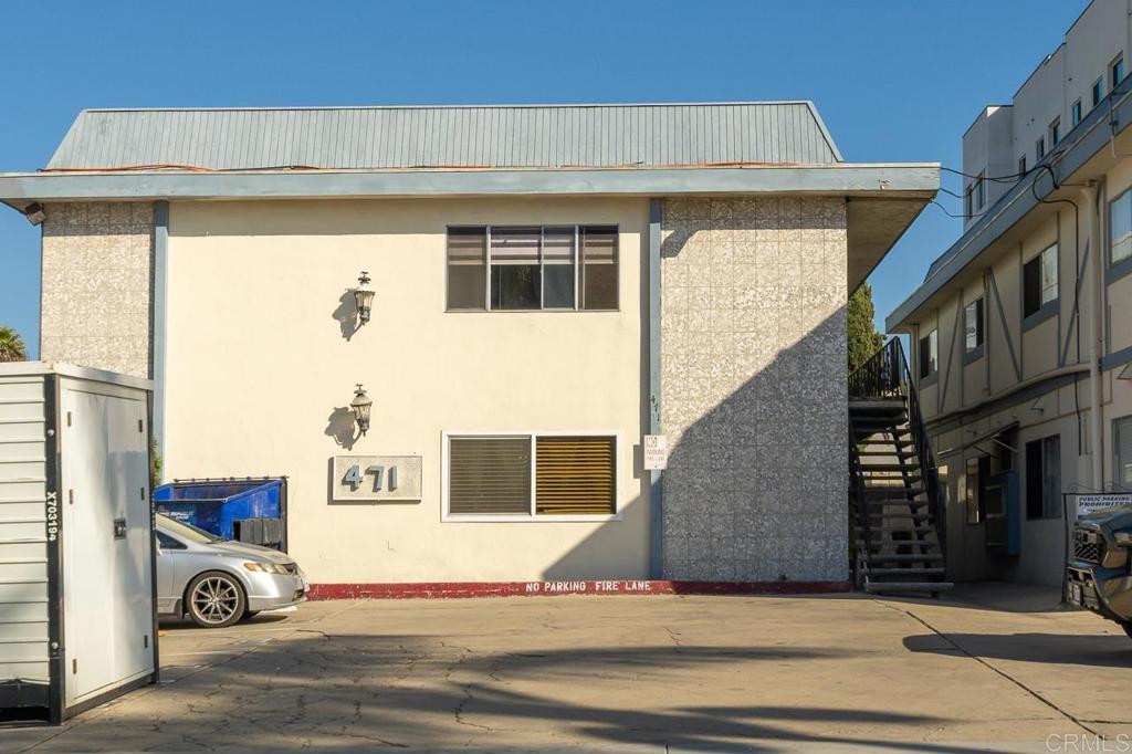 Two-story building marked 471 with textured facade panels and an exterior stairway.