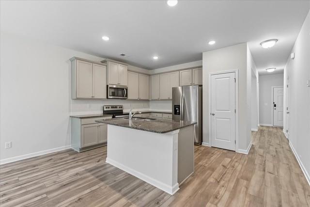 Kitchen with gray cabinets, stainless steel appliances, and a granite-topped island.