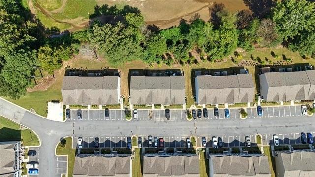 Aerial view of attached townhomes, parking rows, and trees along the complex.