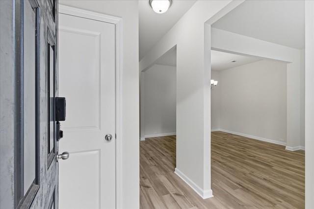 Vacant entry opens to a room with light wood-look flooring and a white dividing column.