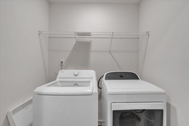 Laundry room with a top-load washer, front-load dryer, and wire shelf.