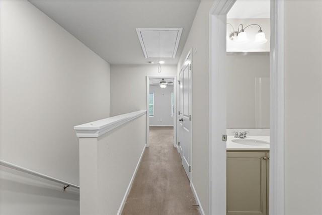 Upstairs hallway with wood-look floors, stair railing, and an open bathroom vanity.