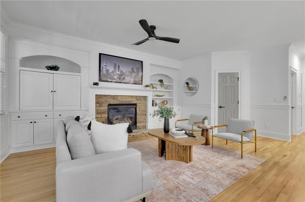 Staged living room with a stone fireplace, built-in cabinetry, and white sofa.