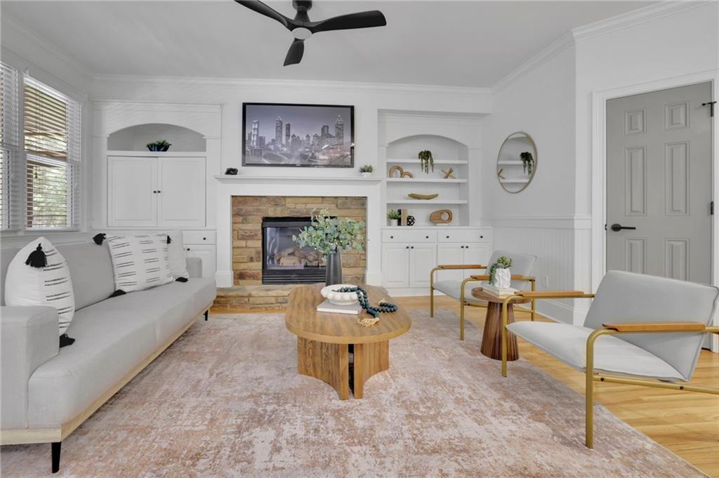 Living room with a brick fireplace, white built-ins, gray seating, and a wooden coffee table.