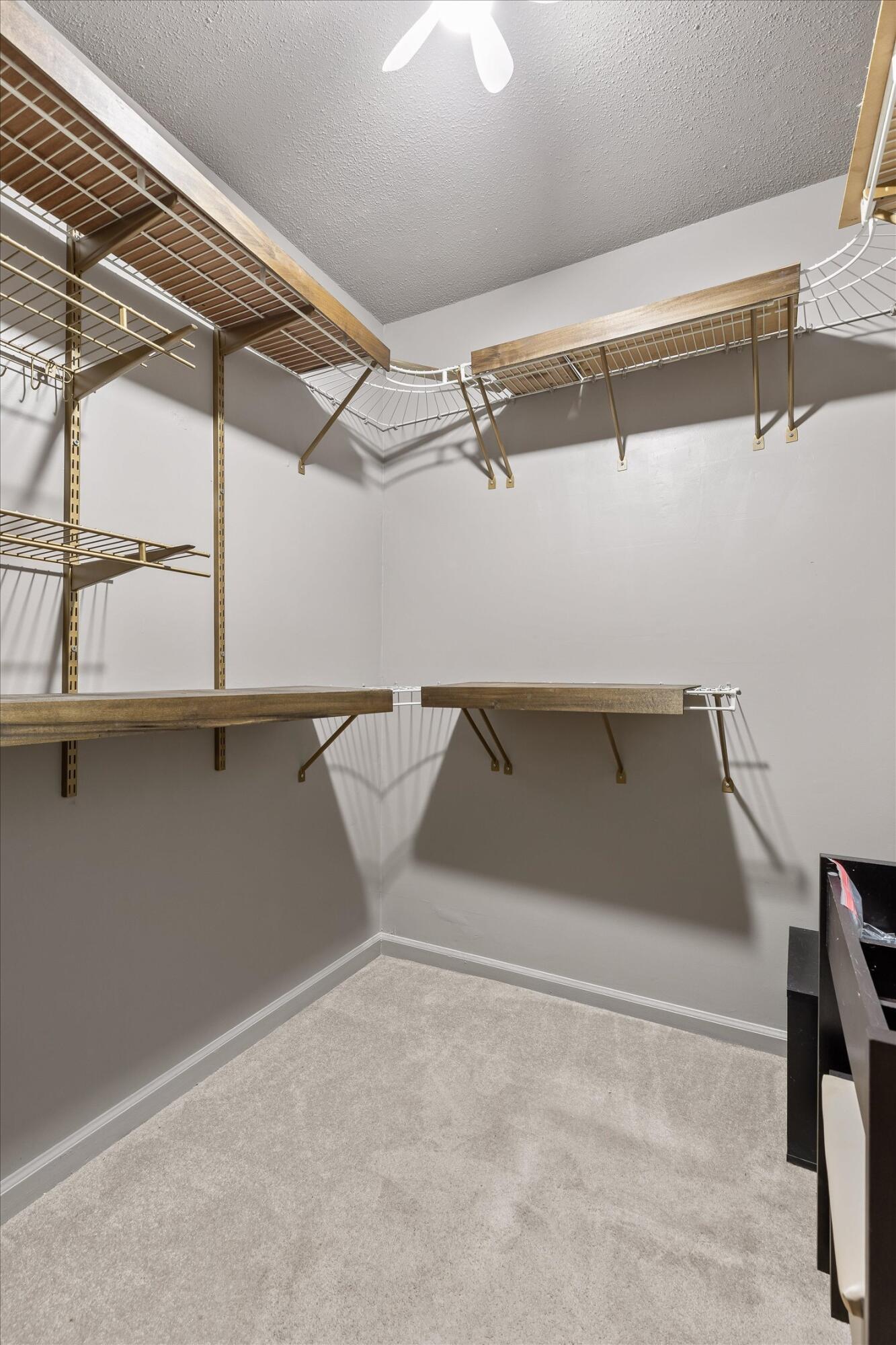Empty walk-in closet with extensive open shelving and hanging rods