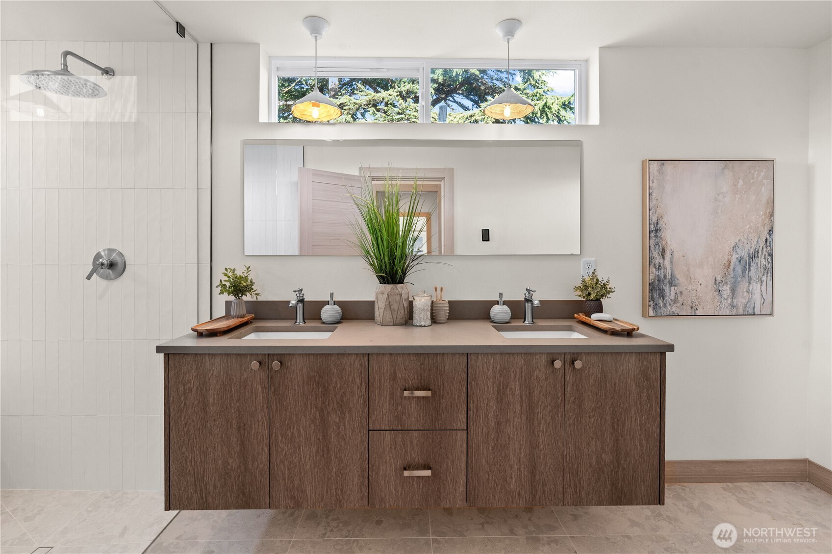 Bathroom with a double-sink wood vanity, wide mirror, and tiled walk-in shower.