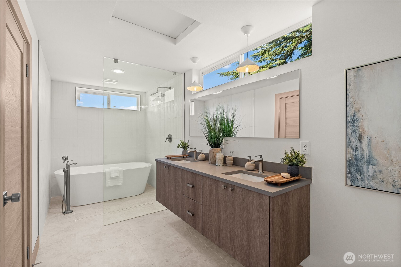 Modern bathroom with a freestanding tub, glass shower, and long double-sink vanity.