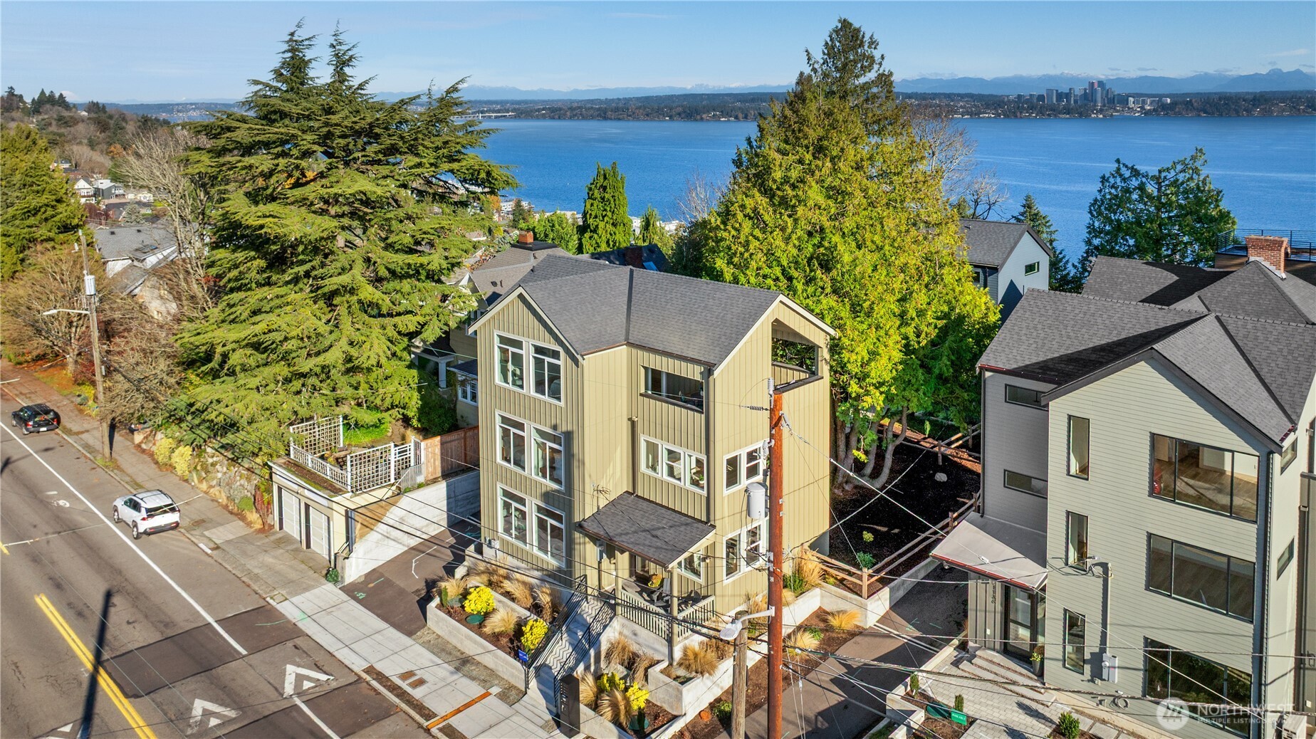 Aerial view of a three-story Seattle home with Lake Washington and the skyline beyond.