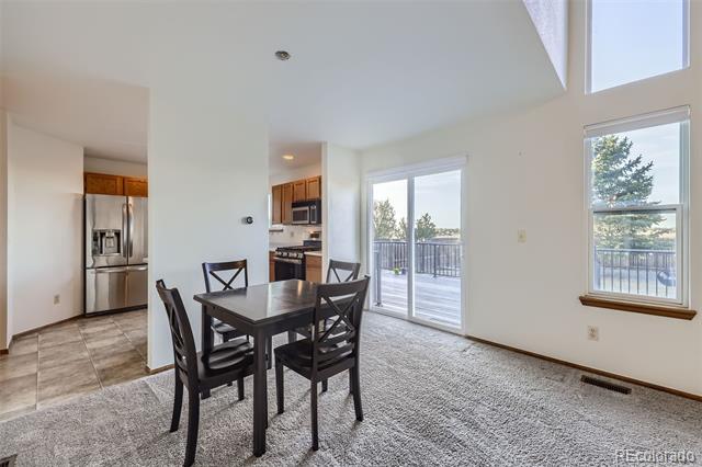 Dining area with a dark wood table beside sliding glass doors to a deck.