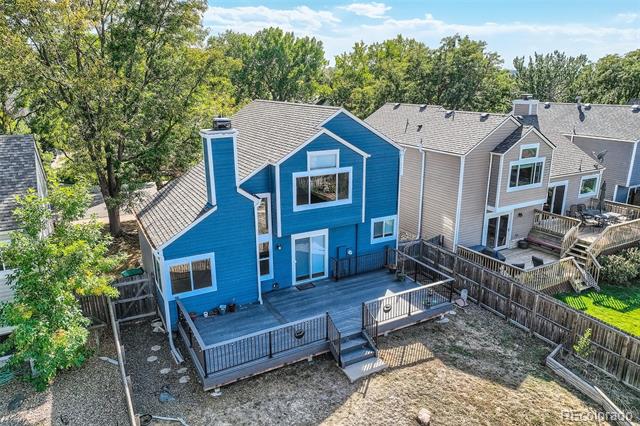 Rear of a blue two-story home with a large multi-level deck, viewed from above.