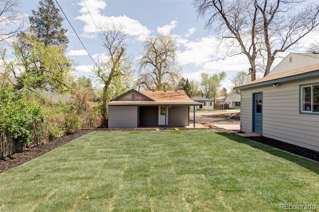 Backyard lawn with a detached covered patio and the side of the house.