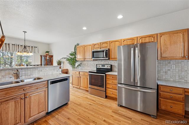 Kitchen with wood cabinets, stainless steel appliances, and a sink island.