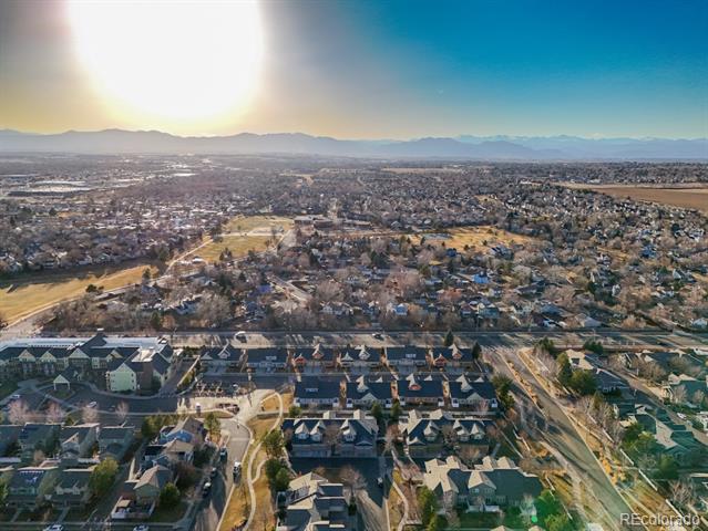 Aerial view of a suburban neighborhood with distant mountains and open fields.