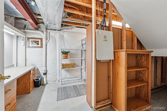 Basement utility area with a concrete floor, metal shelving, and built-in wooden storage shelves.