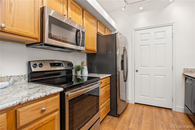 Kitchen with wood cabinets, granite counters, and stainless steel appliances.