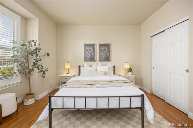 Staged bedroom with a black metal bed, matching bedside lamps, and a large window with blinds.