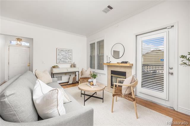 Living room with a gray sectional, round coffee table, fireplace, and glass patio door.