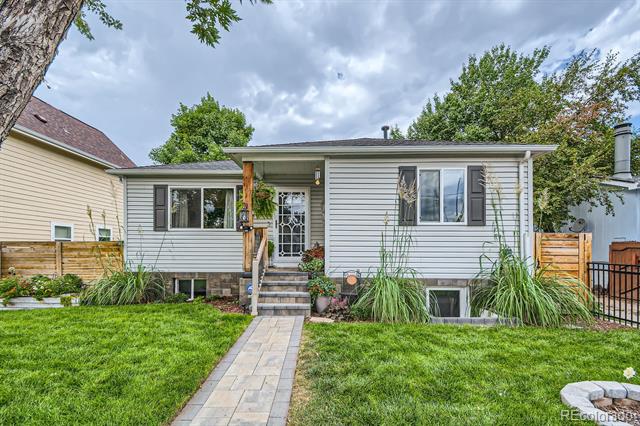 Single-story home with a covered entry, dark shutters, and a paved walkway across the front lawn.