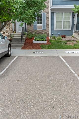 Home exterior with brick and blue siding, front steps, landscaping, and a visitor parking space.