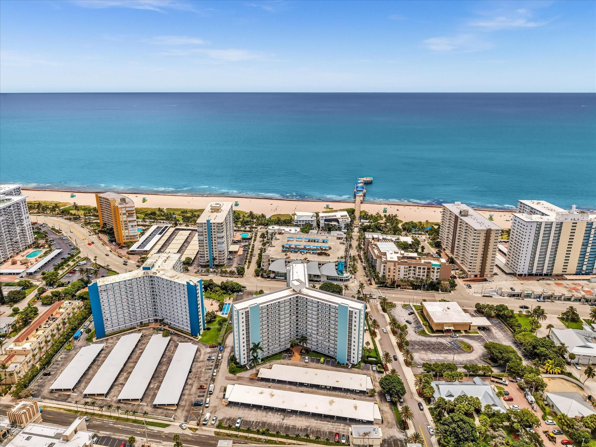 Aerial view of beachfront condominiums, sandy beach, and Atlantic Ocean in Pompano Beach.