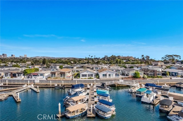 Aerial view of a Newport Beach marina, with docked boats and waterfront homes along the opposite shore.