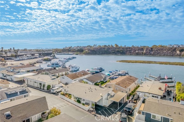 Waterfront homes and marina beside a calm bay, viewed from above with boats and docks.