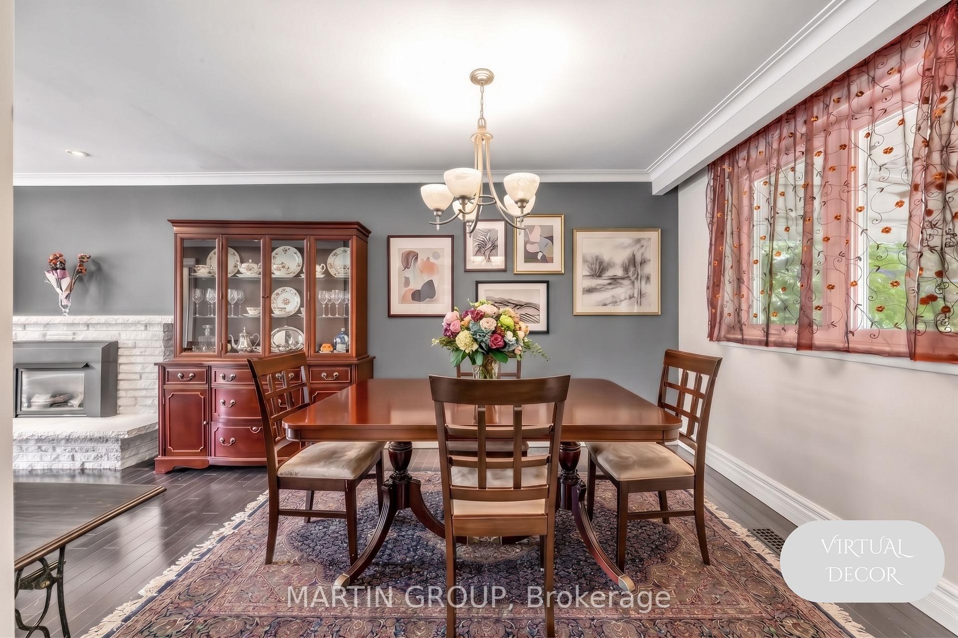 Dining room with a dark wood table, glass-front china cabinet, and white brick fireplace.