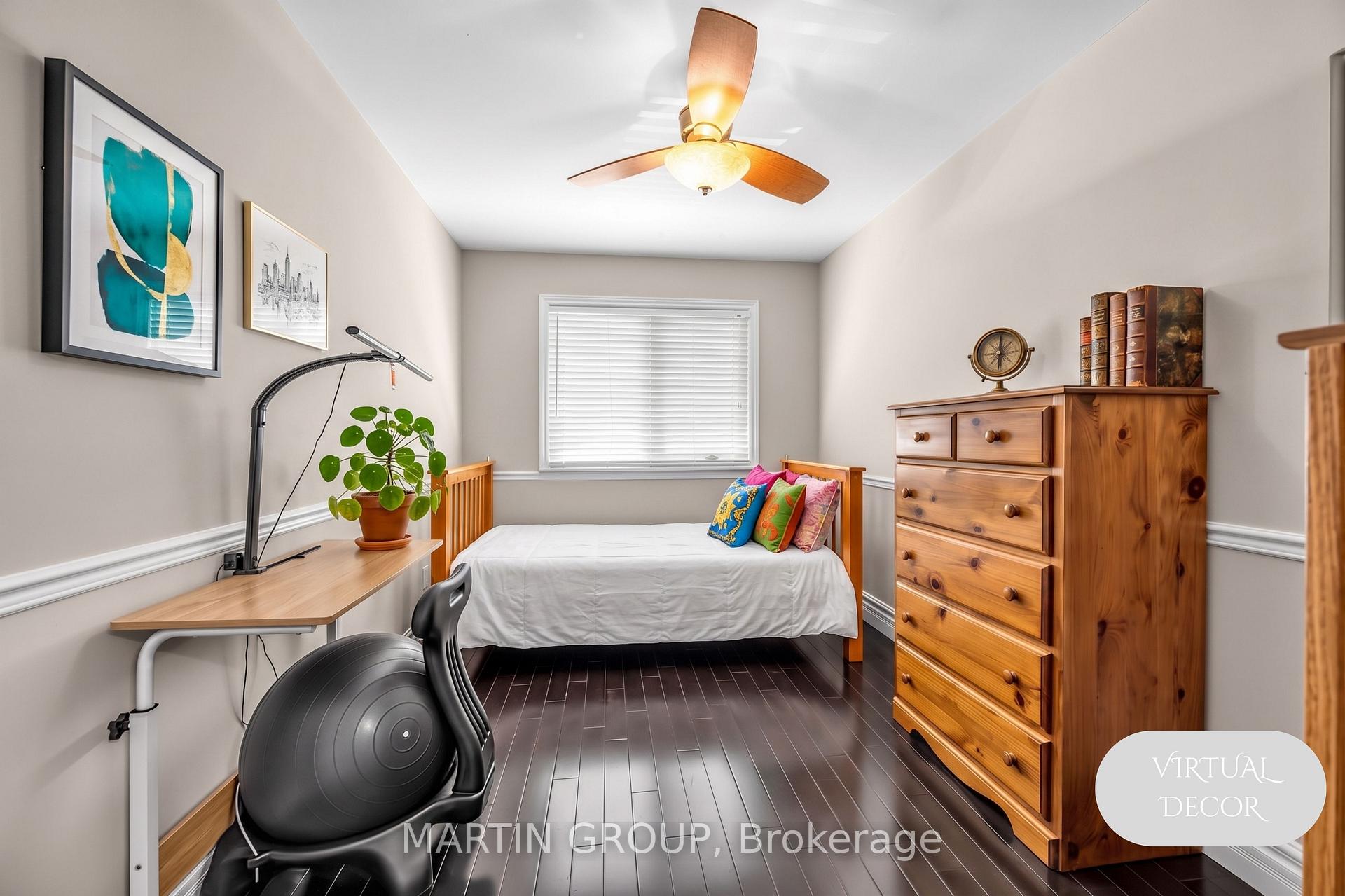Bedroom with a single bed, colorful pillows, wooden dresser, desk, and exercise ball.