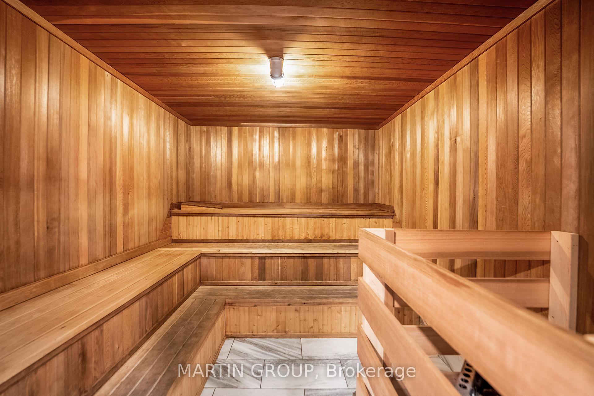 Wood-paneled sauna with tiered benches and a tiled floor.