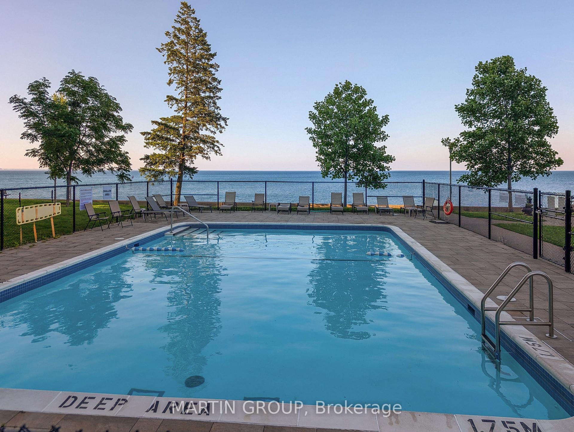 Outdoor pool and lounge deck overlooking the water at sunset.