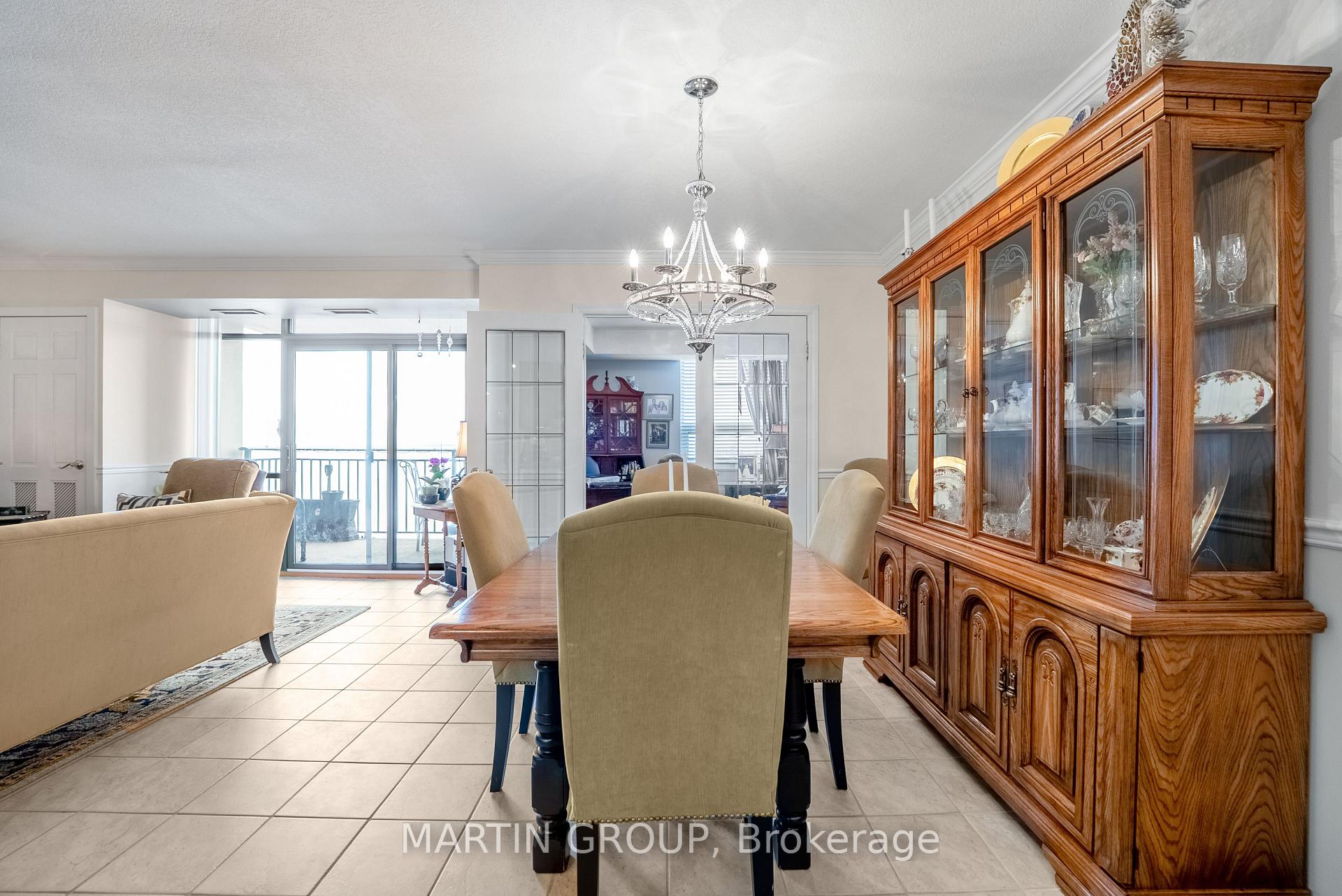 Condo dining area with a large wooden china cabinet and sliding balcony doors.