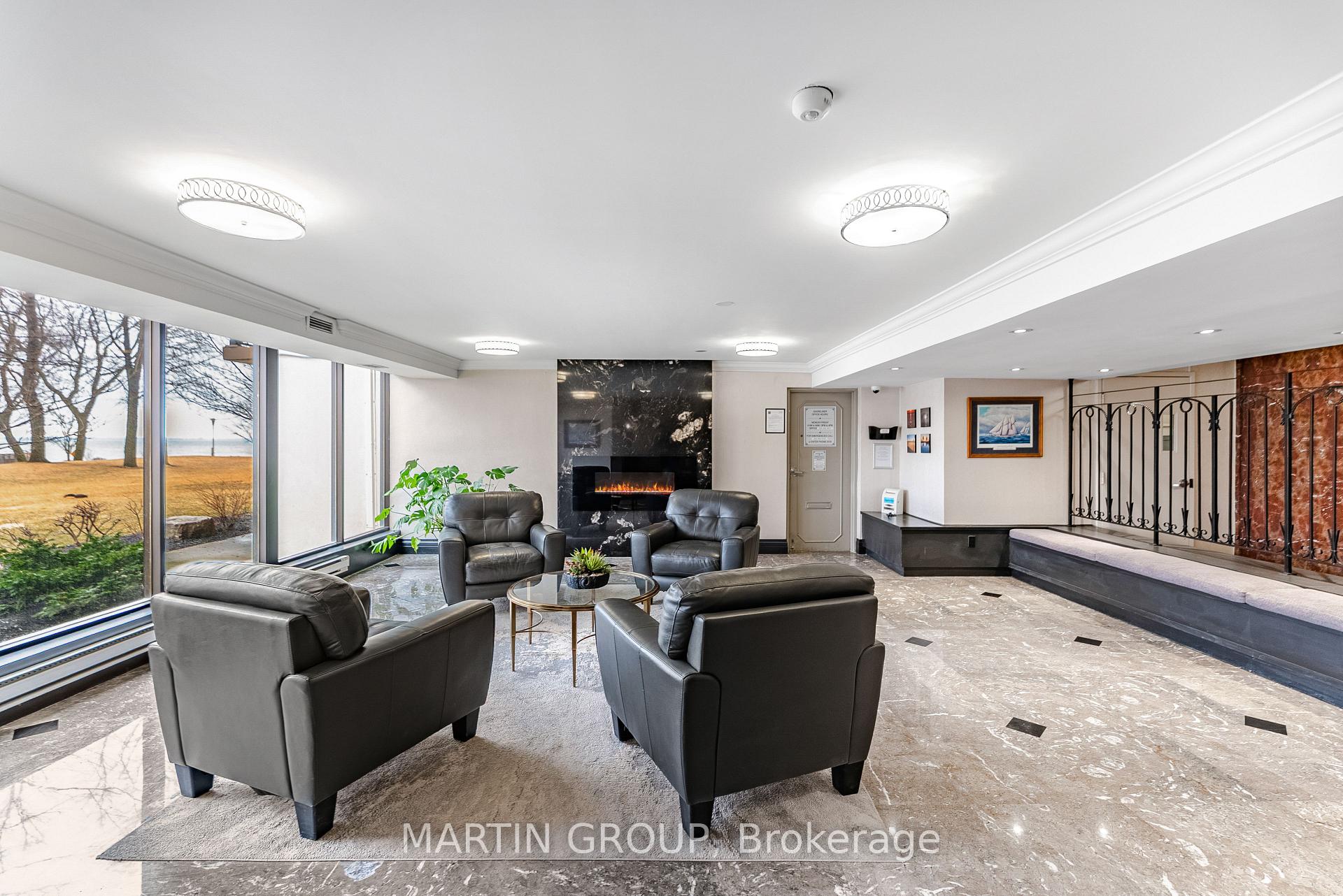 Condominium lobby lounge with leather chairs, a marble fireplace, and large waterfront-facing windows.