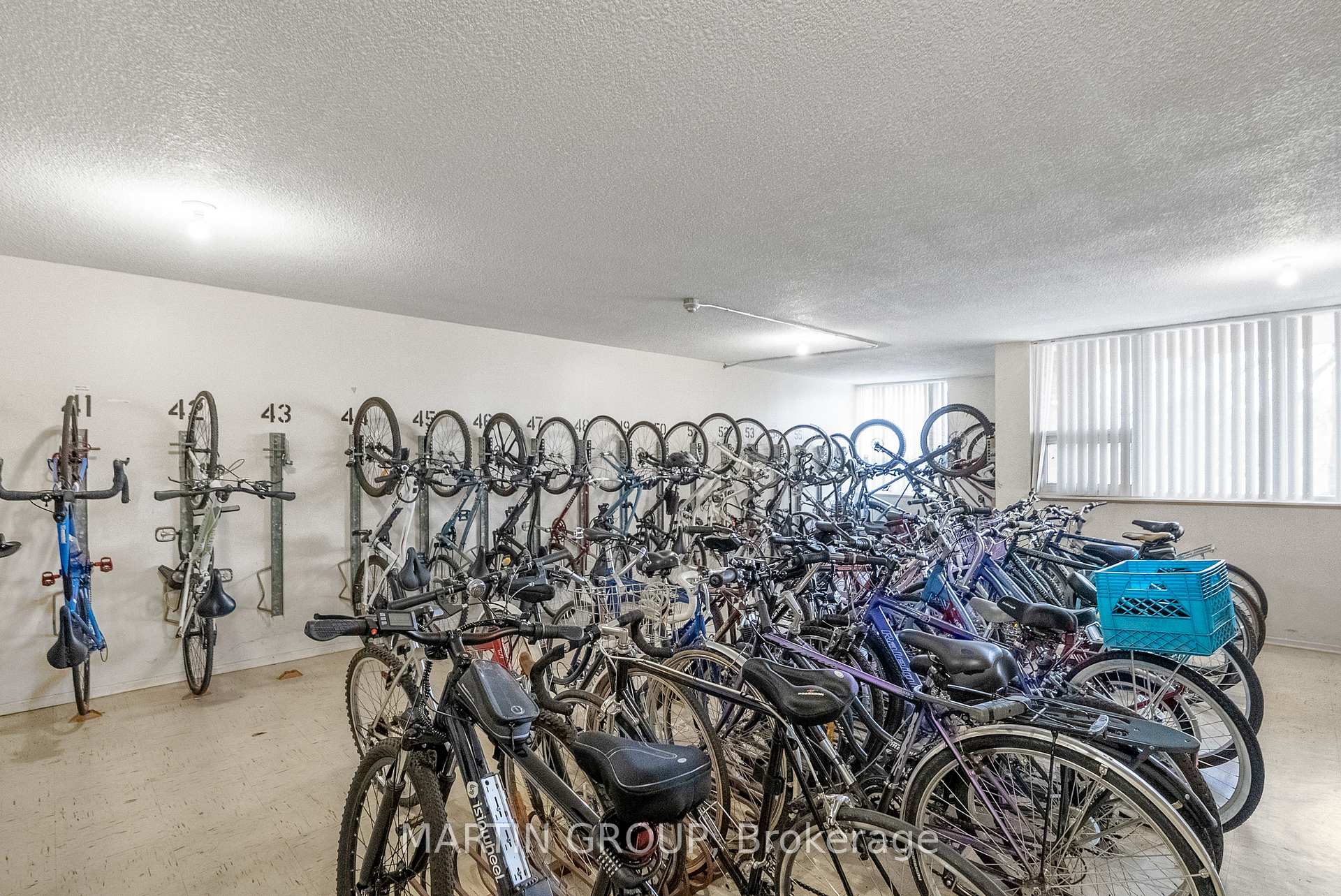 Bicycle storage room with crowded bike racks and rows of bicycles.