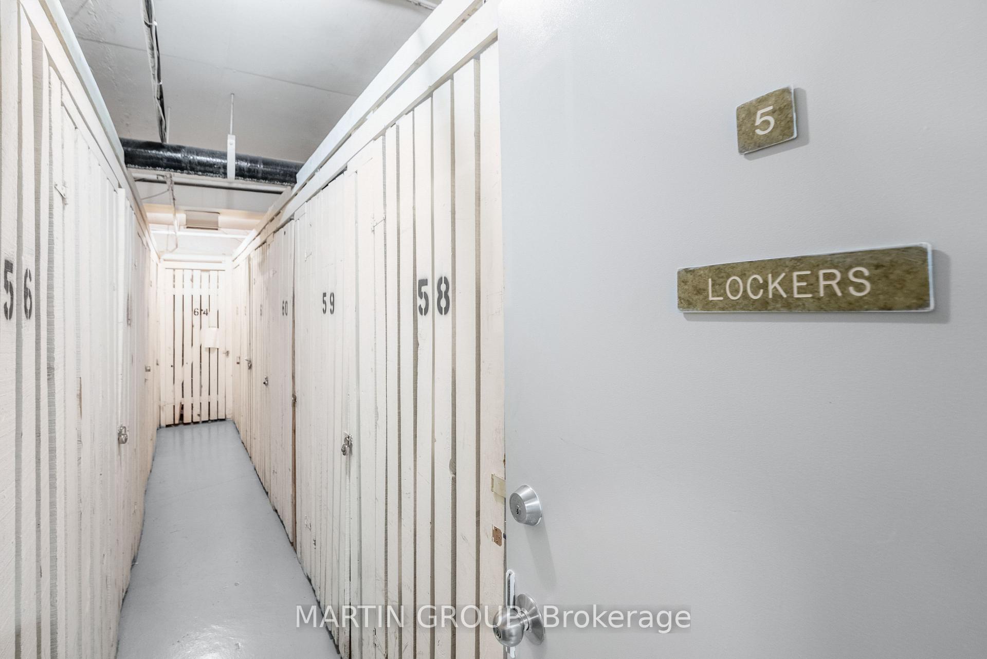 Storage corridor lined with numbered lockers, beside a wall sign marked “LOCKERS.”