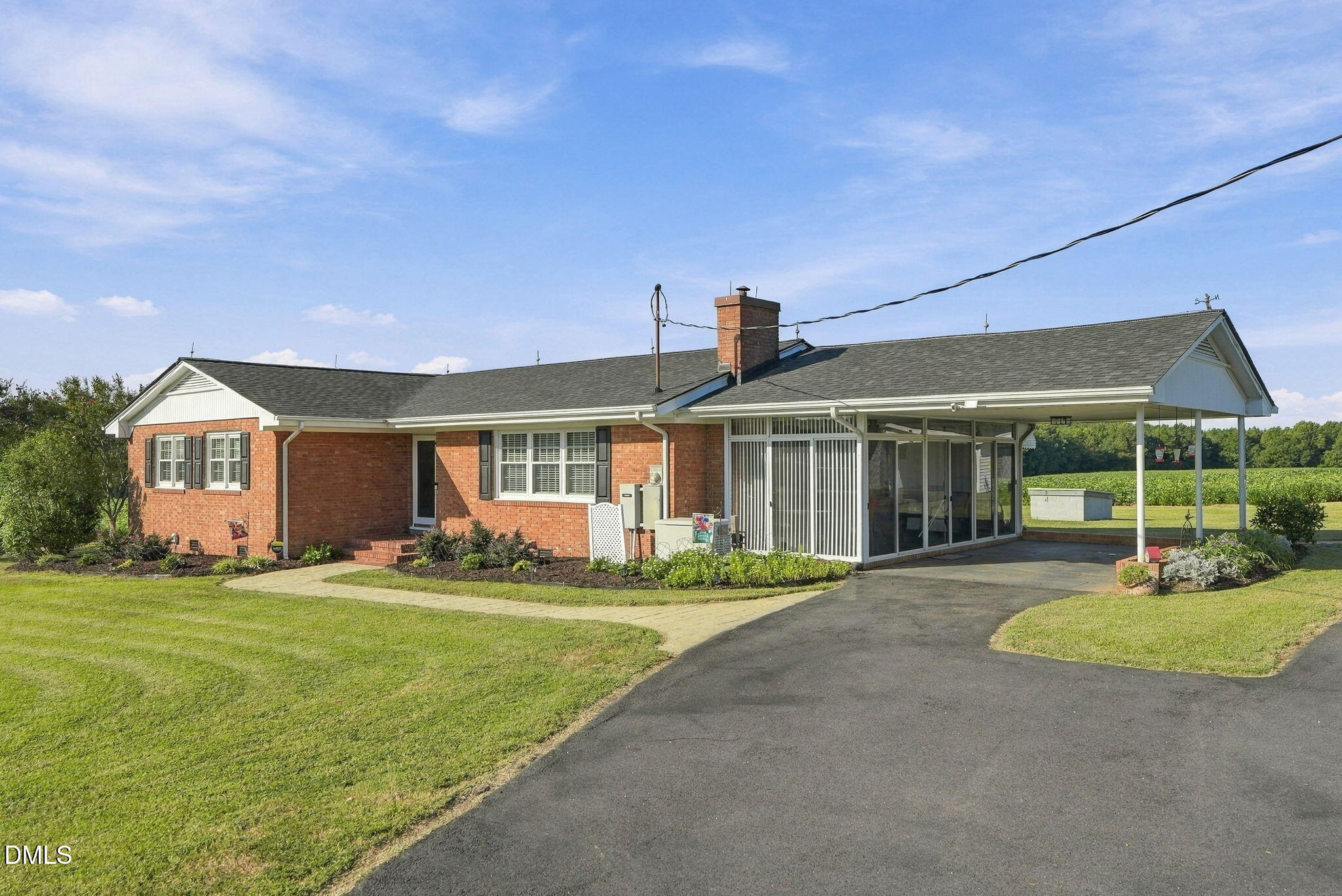 Red brick ranch house with a screened porch, covered parking, and a wide paved driveway.