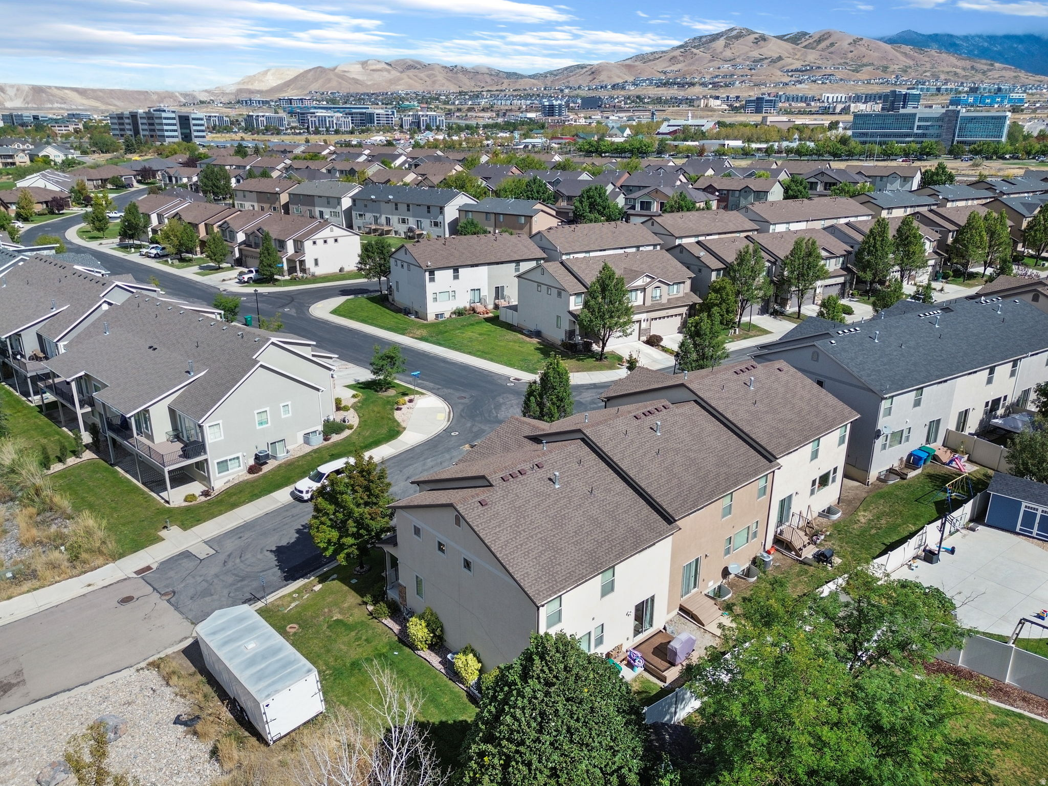 Aerial view of two-story homes and neighborhood streets with mountains in the distance.