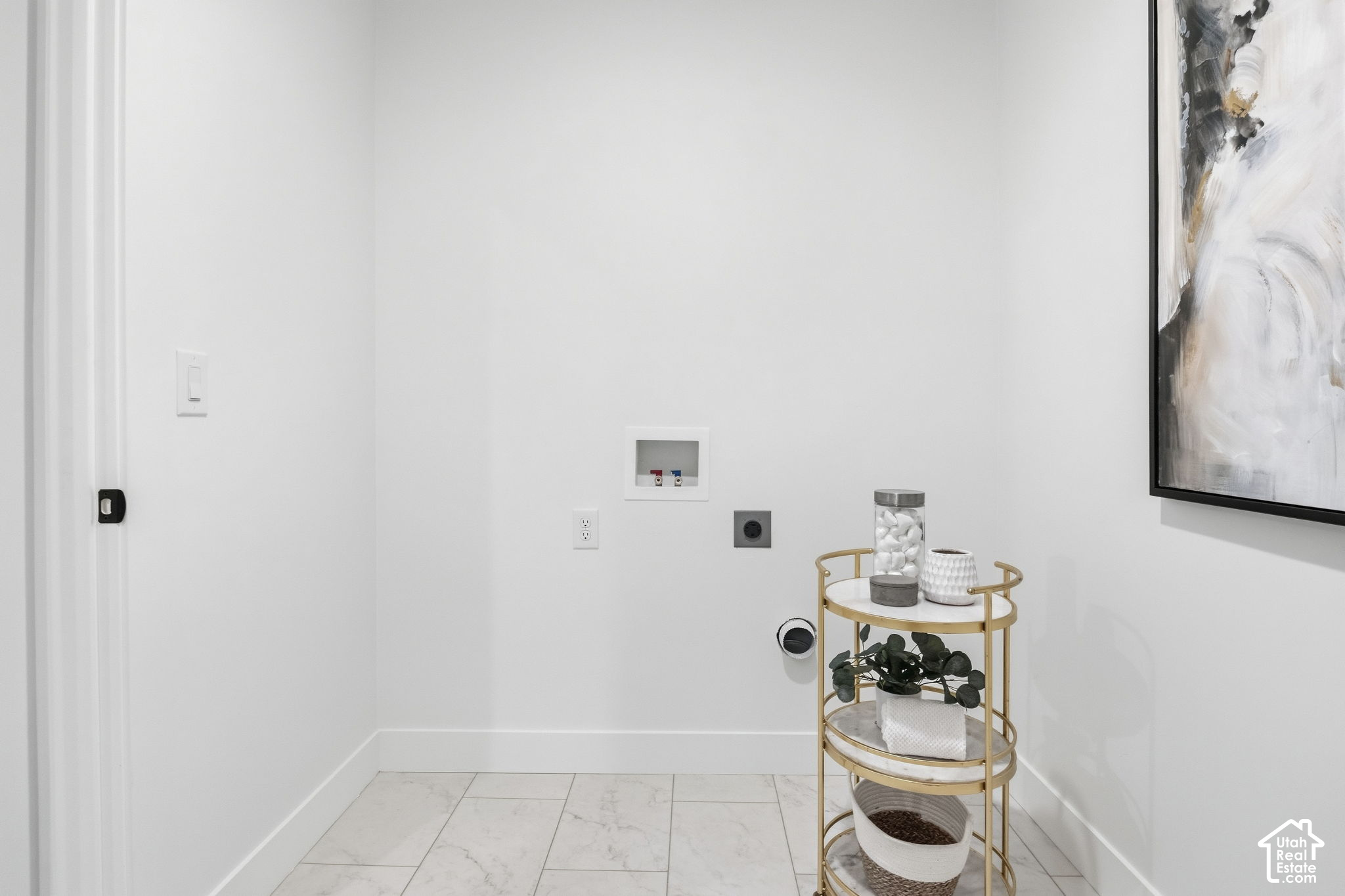Laundry room with washer and dryer hookups, marble-look tile, and a gold storage cart.