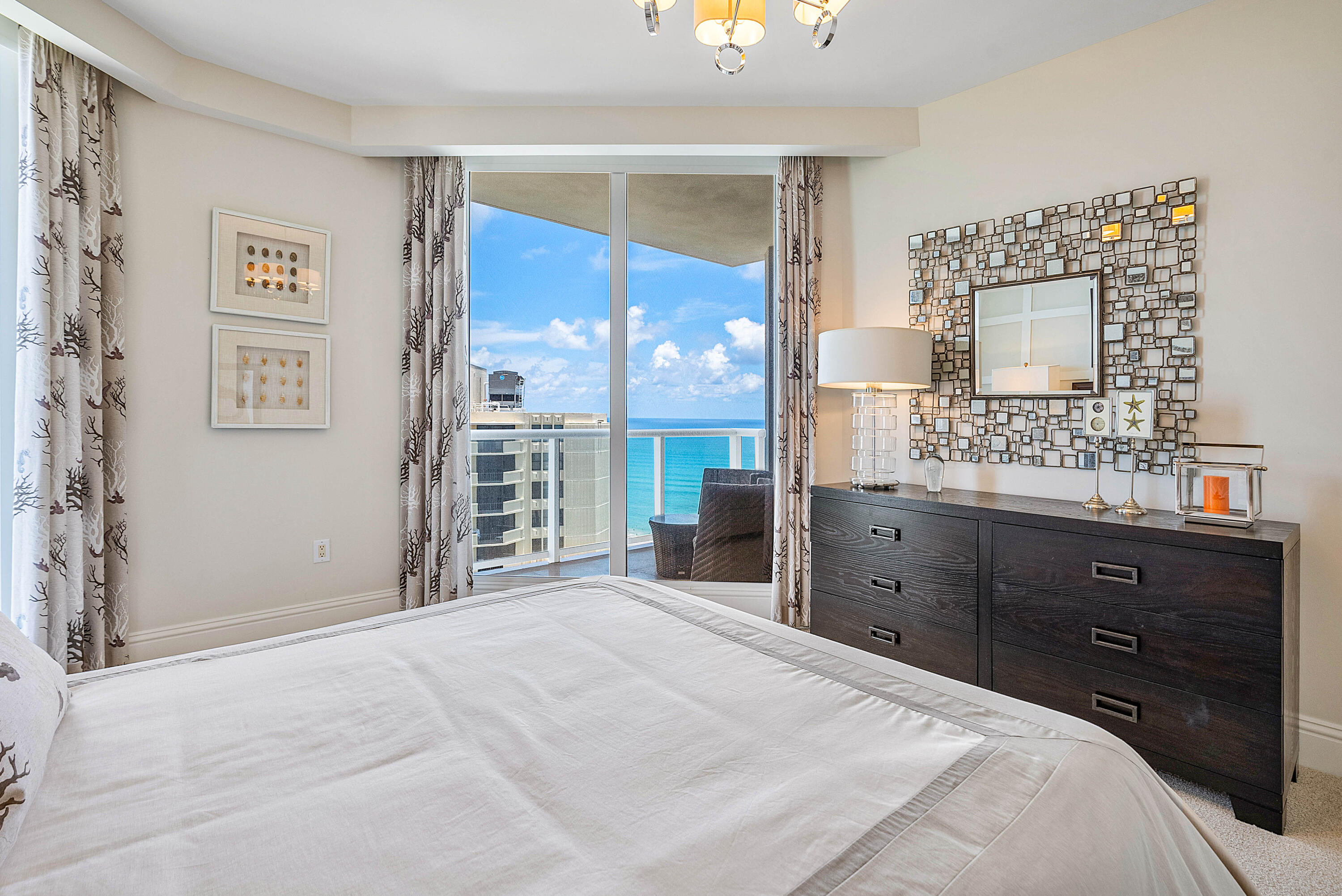 Bedroom with a white bed and ocean views through sliding balcony doors