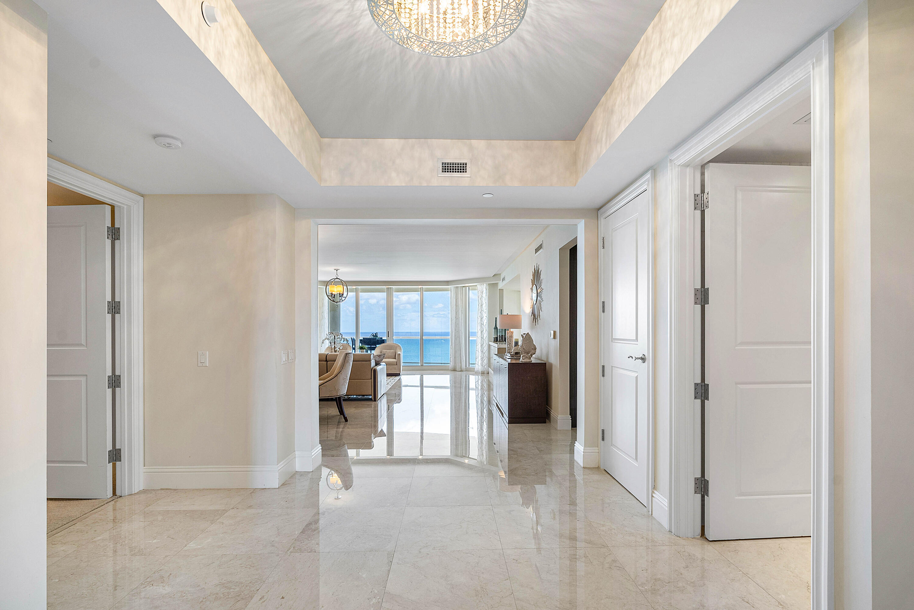 Condominium entry hall opens to a furnished living room with ocean views.
