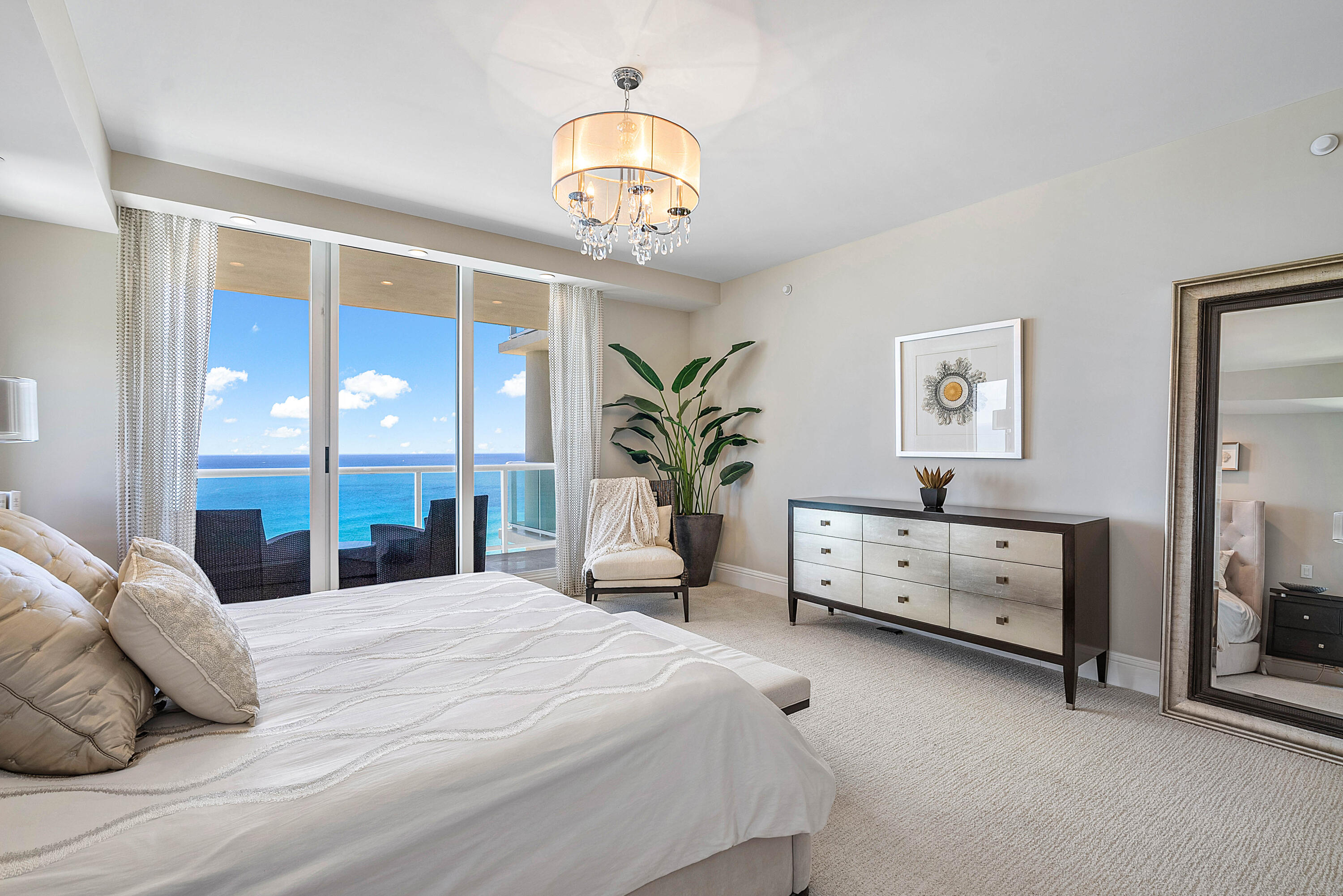 Bedroom with a king bed and sliding glass doors overlooking the ocean.