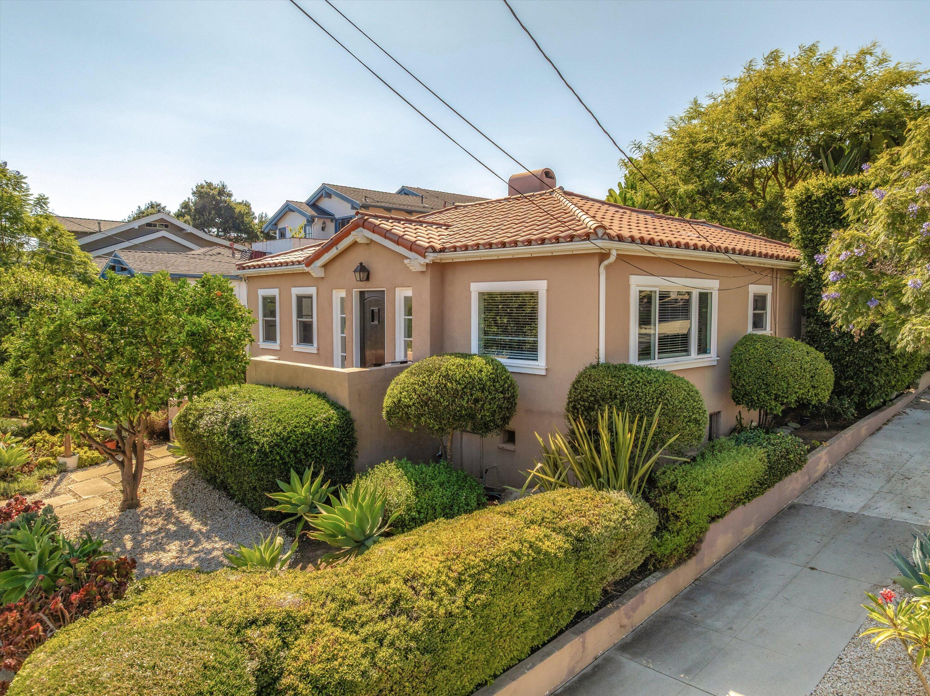 Single-story stucco home with a terracotta tile roof and a neatly landscaped front yard.