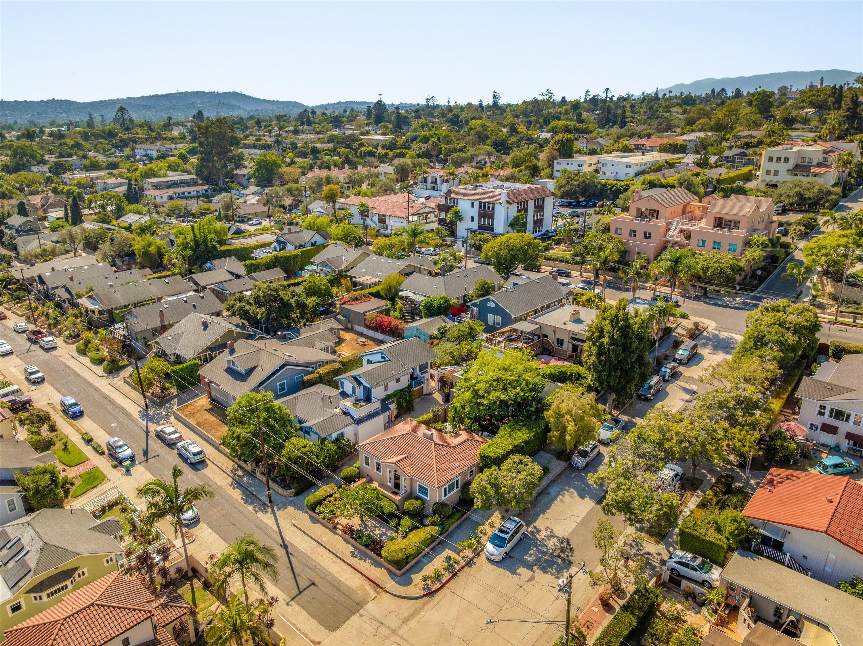 Aerial view of a Santa Barbara neighborhood with tree-lined streets and hills in the distance.