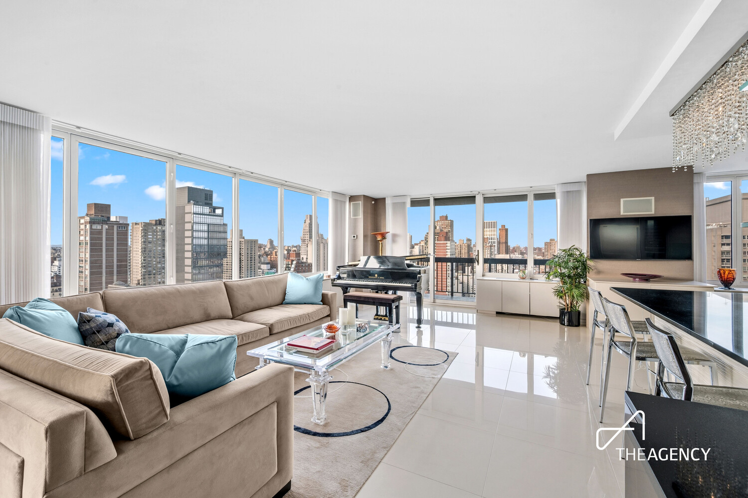 High-rise living room with floor-to-ceiling Manhattan views, a grand piano, and a beige sectional sofa.