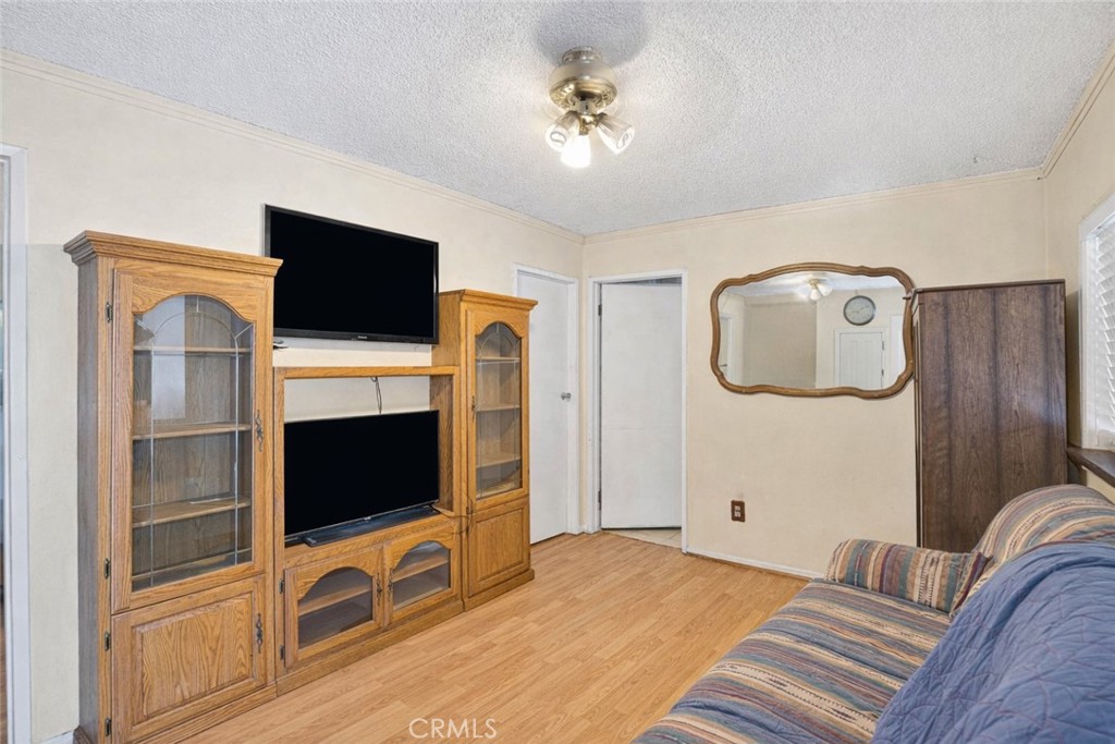 Living room with a wooden entertainment center, two televisions, and a patterned sofa.