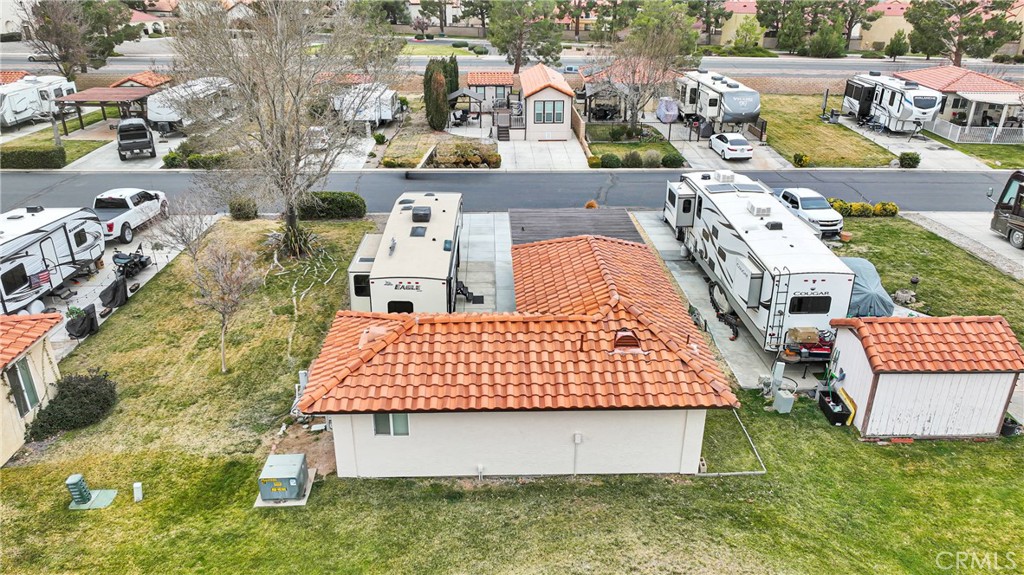 Aerial view of a small red tile-roofed building surrounded by parked RVs and paved pads.