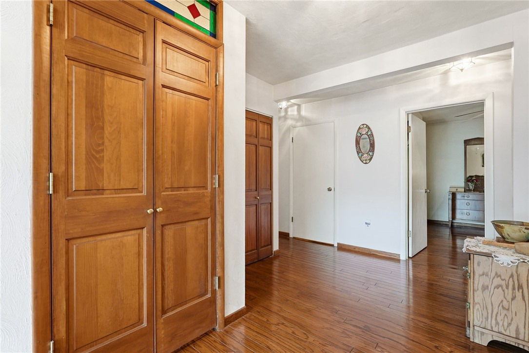 Entry hall with a paneled wooden double door, stained-glass transom, and polished hardwood floors.