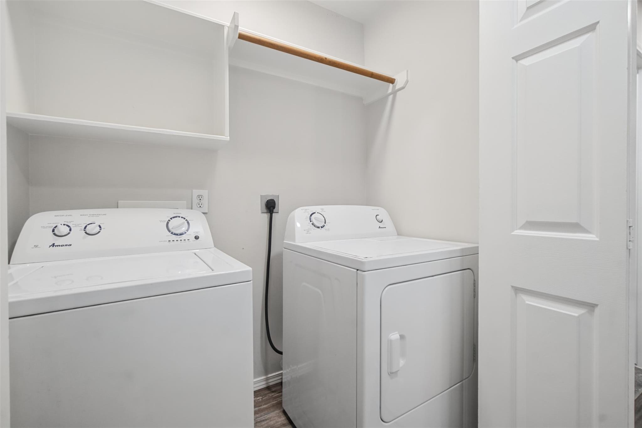 Laundry room with a top-loading washer, front-loading dryer, and built-in shelf.
