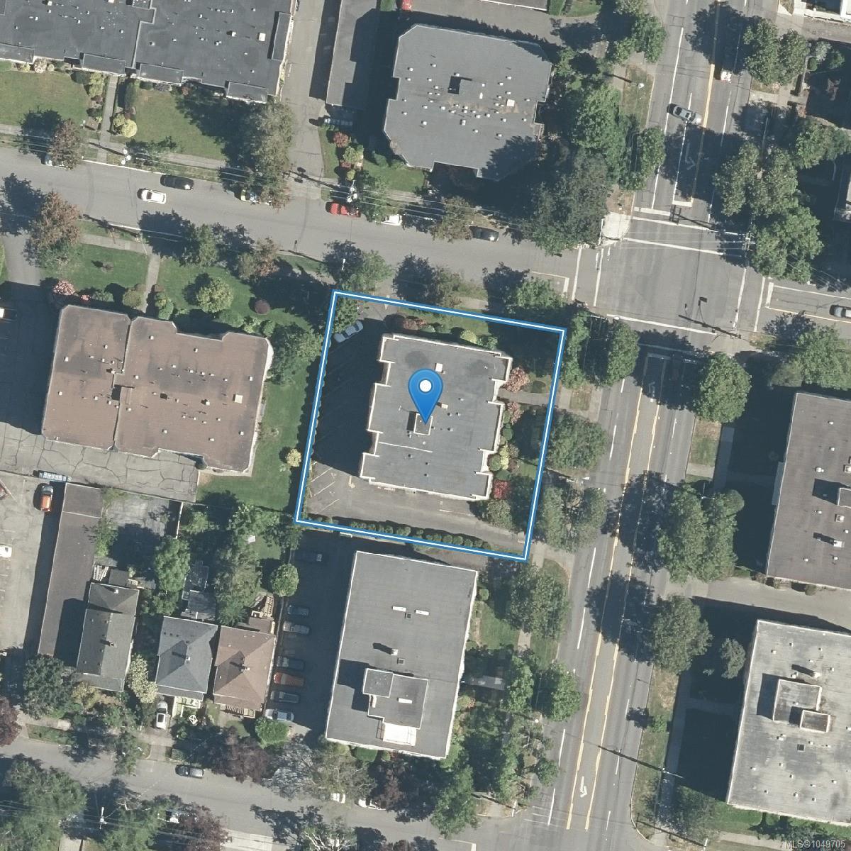 Aerial view of the outlined apartment building, marked with a blue map pin among tree-lined streets.