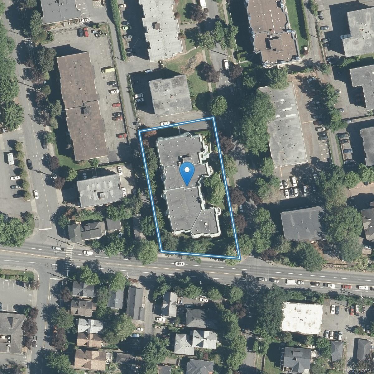 Aerial view of an urban building outlined in blue, marked with a map pin.